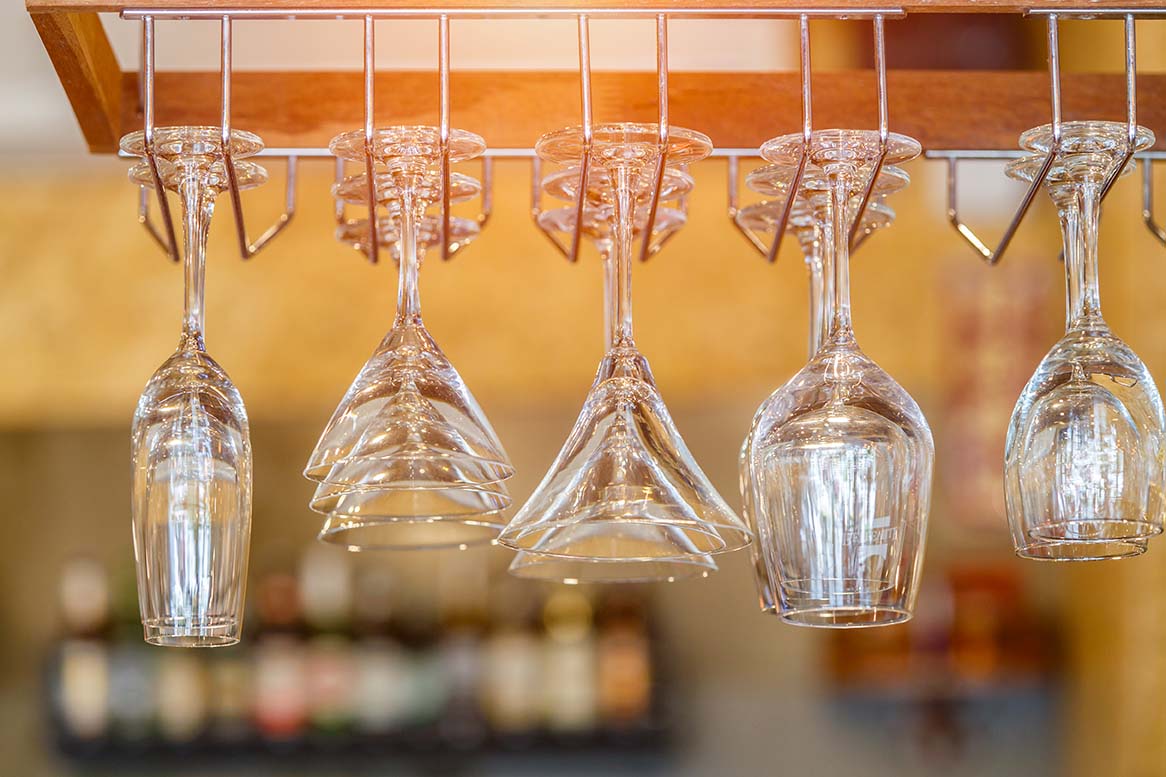 Diversi bicchieri e jigger in metallo e misurino sono supporti sul bancone  del bar barista sfocato sullo sfondo